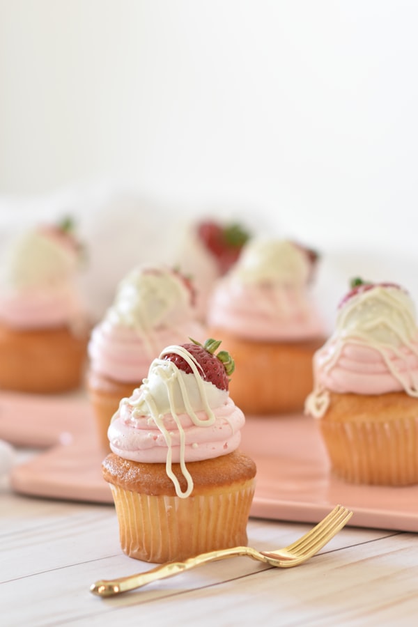 Strawberry cupcakes with white chocolate drizzle and fresh strawberries